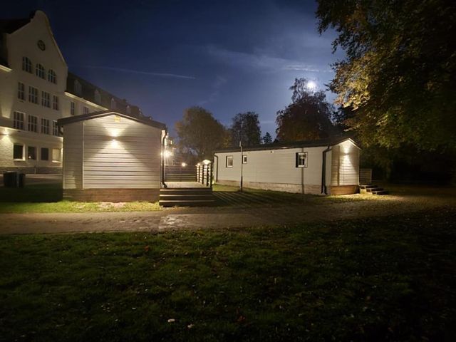 Två villavagnar på gräsmattan framför huset en kväll